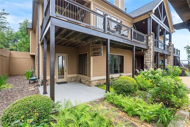 49 Waterside Dr SE, Cartersville, GA 30121 - rear view of house with stone siding, a patio, and a chimney