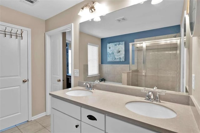 bathroom featuring a shower with shower door, tile patterned floors, and vanity