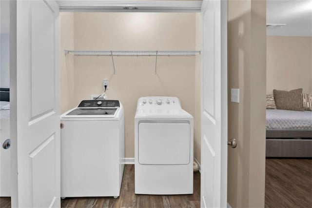 laundry room with dark hardwood / wood-style flooring and washing machine and clothes dryer