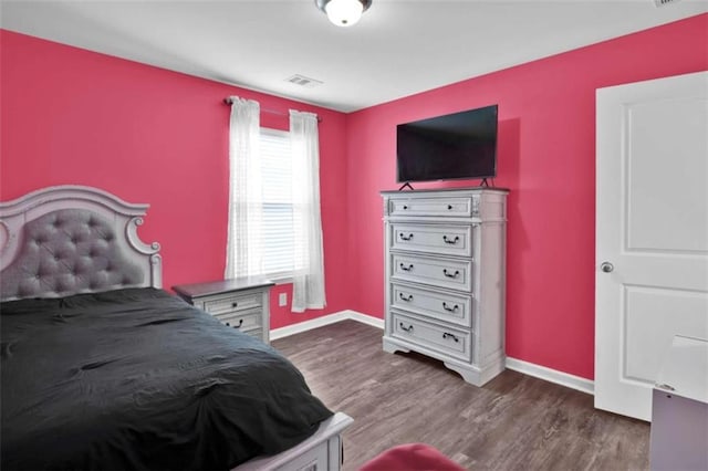 bedroom with dark hardwood / wood-style flooring