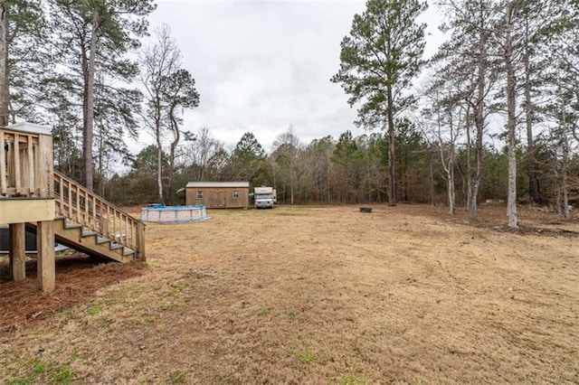 view of yard featuring a swimming pool side deck and an outdoor structure