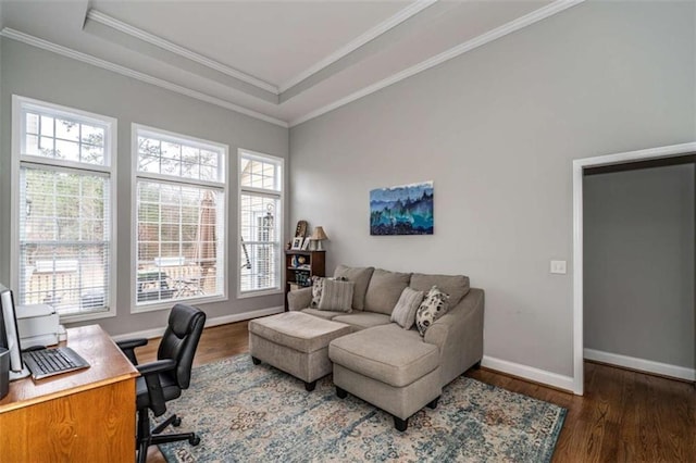 home office with ornamental molding, dark wood-type flooring, a raised ceiling, and a healthy amount of sunlight