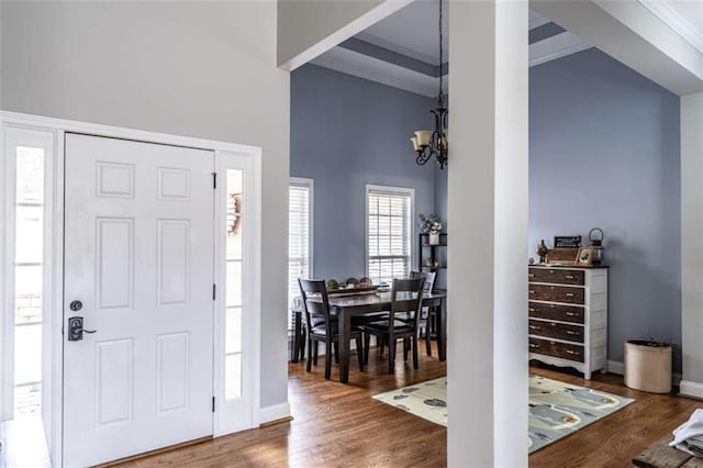 entrance foyer with crown molding and dark wood-type flooring