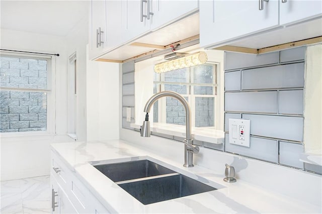 kitchen featuring white cabinetry, sink, and a wealth of natural light