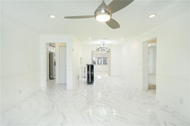 spare room with crown molding and ceiling fan with notable chandelier