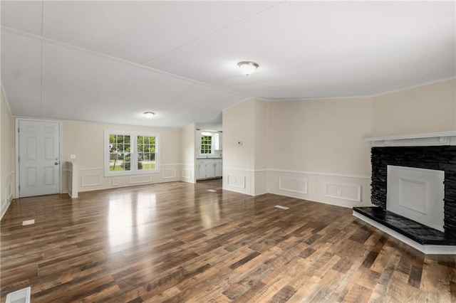 unfurnished living room with a fireplace and dark wood-type flooring