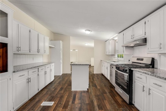 kitchen featuring white cabinetry, sink, dark wood-type flooring, light stone counters, and appliances with stainless steel finishes