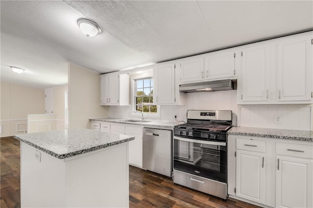 kitchen featuring a center island, light stone countertops, white cabinetry, and appliances with stainless steel finishes