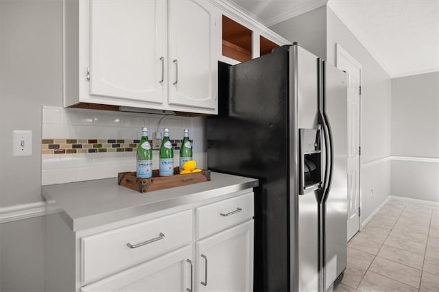 kitchen with white cabinets, light tile patterned floors, stainless steel refrigerator with ice dispenser, and tasteful backsplash