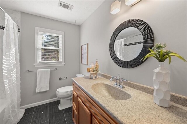 full bathroom featuring shower / tub combo with curtain, vanity, and toilet