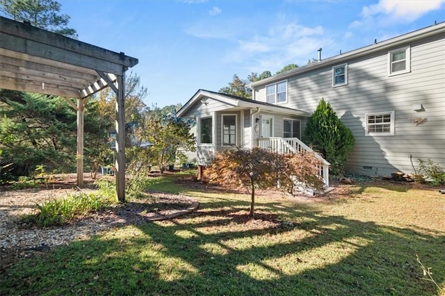 rear view of house featuring a pergola and a yard