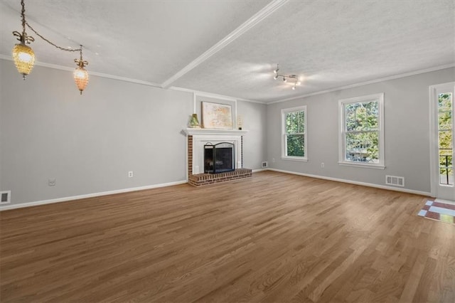 unfurnished living room with a fireplace, hardwood / wood-style flooring, plenty of natural light, and crown molding