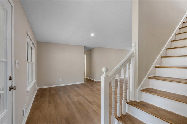 stairway with hardwood / wood-style floors