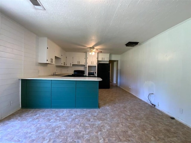 995 Gadsden Rd, Cave Spring, GA 30124 - kitchen with a peninsula, freestanding refrigerator, tile patterned floors, stove, and white cabinetry