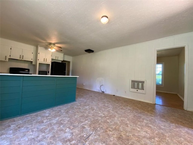 995 Gadsden Rd, Cave Spring, GA 30124 - kitchen with black fridge, heating unit, ceiling fan, white cabinetry, and a textured ceiling