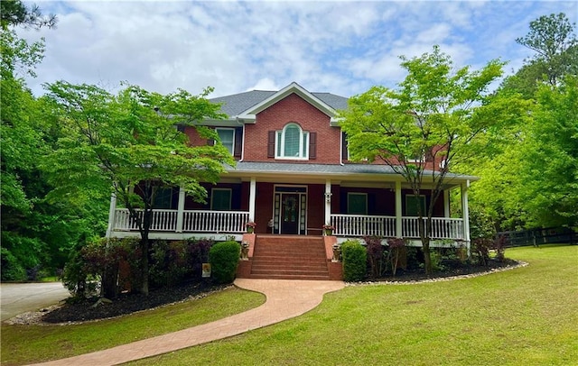 view of front of home featuring fence, stairway, covered porch, and a front yard
