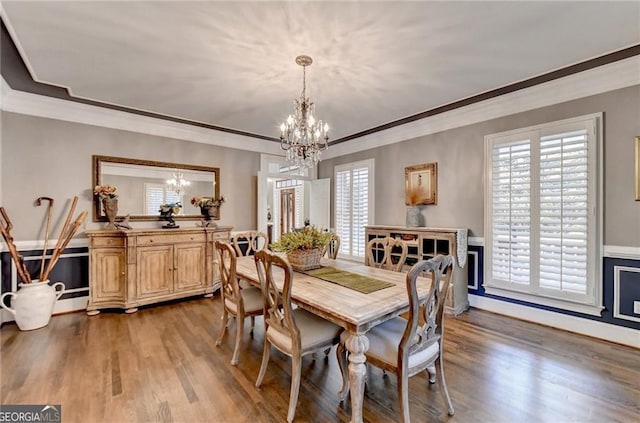 dining room featuring crown molding, an inviting chandelier, wood finished floors, and baseboards