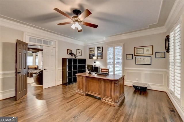 office space with ornamental molding, ceiling fan, wood finished floors, and a decorative wall