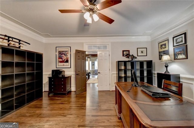 office space featuring a wainscoted wall, wood finished floors, ceiling fan, and crown molding