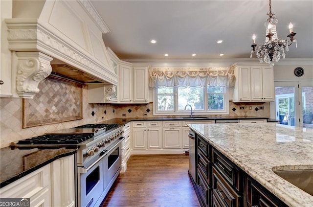 kitchen featuring appliances with stainless steel finishes, custom exhaust hood, plenty of natural light, and a sink