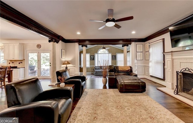 living area featuring ornamental molding, ceiling fan, and a decorative wall