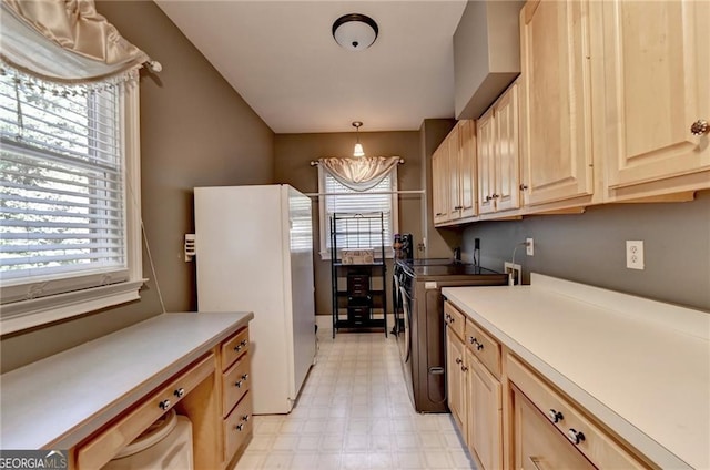 kitchen with light floors, light countertops, light brown cabinetry, and freestanding refrigerator