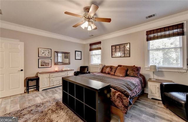bedroom featuring ornamental molding, a ceiling fan, visible vents, and light wood-style floors