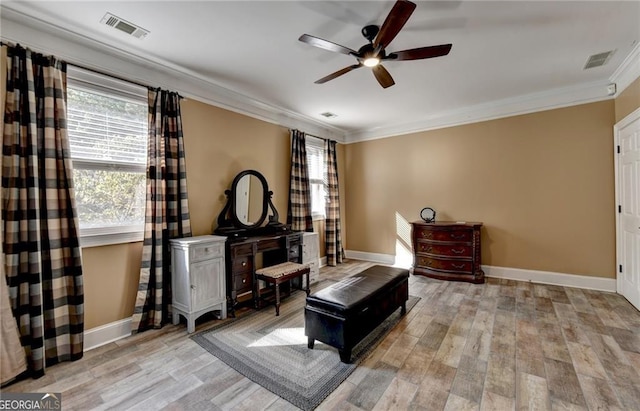 living area featuring visible vents, ornamental molding, a ceiling fan, and light wood finished floors