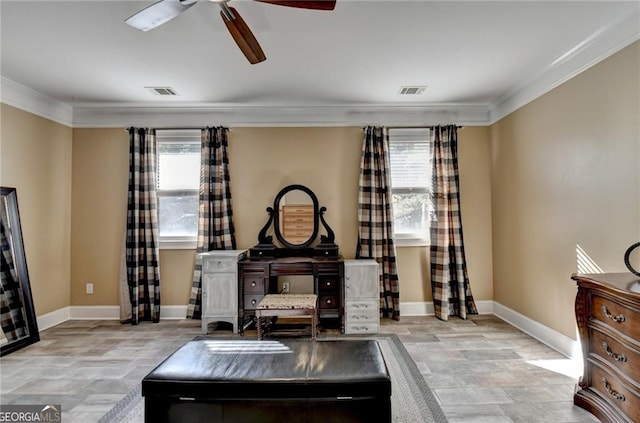 interior space with baseboards, visible vents, a ceiling fan, and crown molding