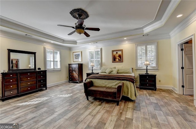 bedroom with baseboards, a raised ceiling, ornamental molding, and light wood-style flooring
