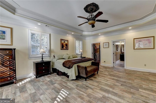 bedroom featuring ornamental molding, light wood-style flooring, and a raised ceiling