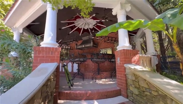 exterior space with an outdoor bar and a ceiling fan