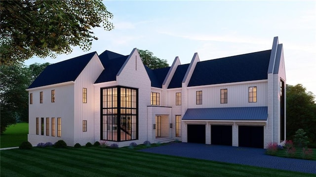 view of front of house with a garage, a front lawn, and aphalt driveway