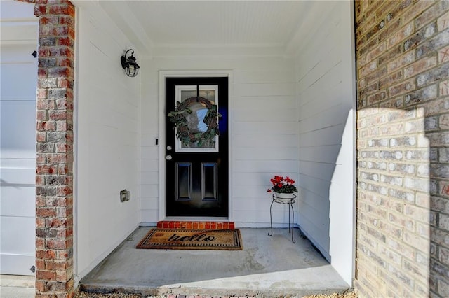 property entrance featuring a garage and brick siding