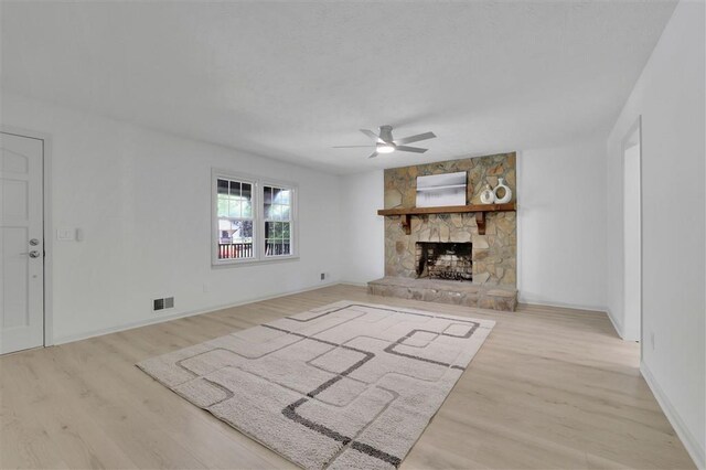 unfurnished living room featuring a textured ceiling, wood finished floors, a ceiling fan, and visible vents
