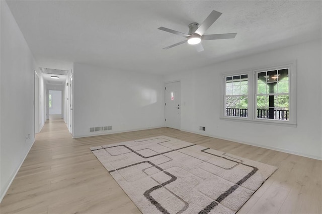 spare room with visible vents, a textured ceiling, a ceiling fan, and wood finished floors