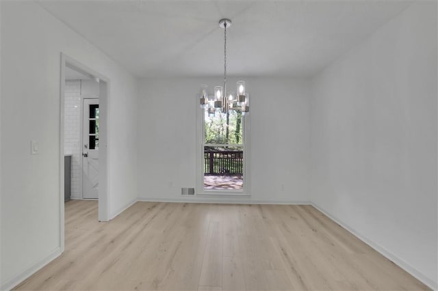 unfurnished room featuring visible vents, baseboards, light wood finished floors, and a chandelier