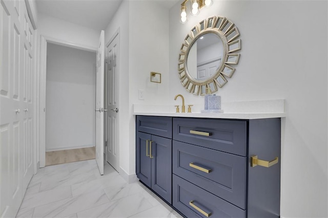 bathroom with baseboards, marble finish floor, and vanity