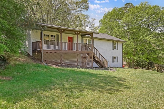 view of front of house with brick siding, a front yard, a porch, and stairway