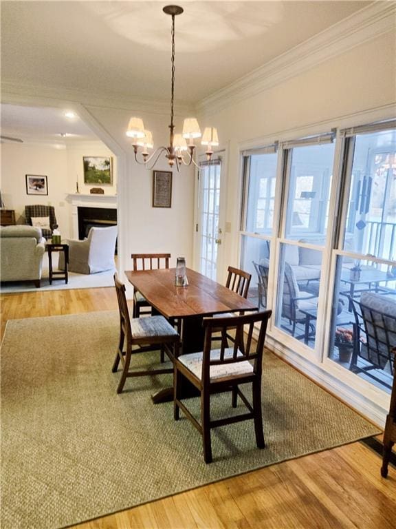 dining area with crown molding, wood-type flooring, and a chandelier