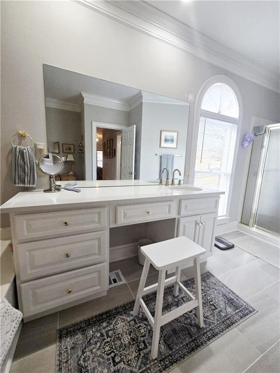 bathroom featuring tile patterned floors, vanity, a shower with door, and ornamental molding