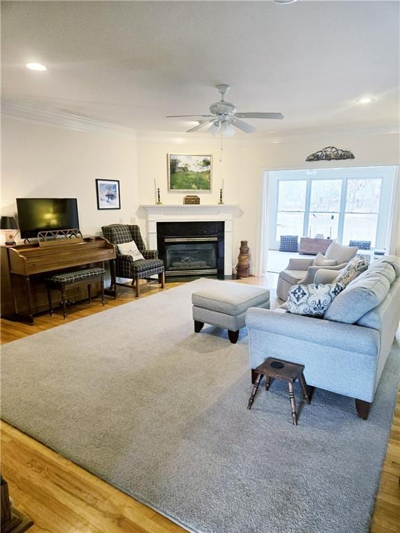 living room with crown molding, hardwood / wood-style flooring, and ceiling fan