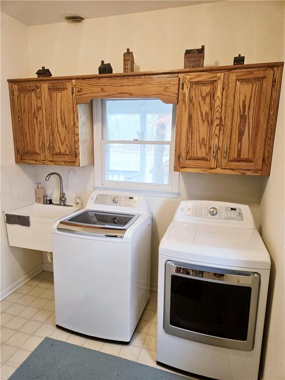 laundry room featuring cabinets, separate washer and dryer, and sink