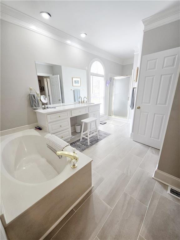 bathroom with visible vents, a stall shower, crown molding, a bath, and vanity