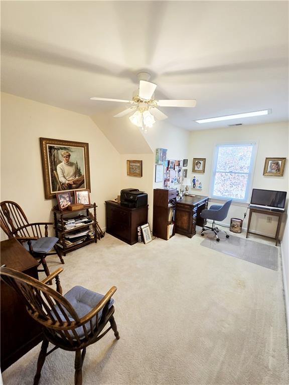 carpeted office with a ceiling fan