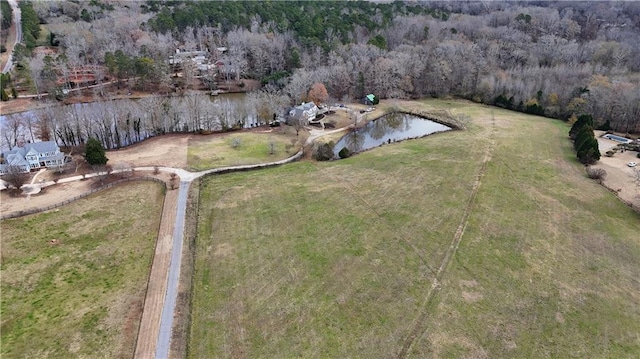 birds eye view of property featuring a view of trees and a water view