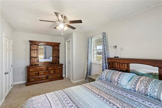 bedroom with crown molding, ceiling fan, baseboards, carpet flooring, and a textured ceiling