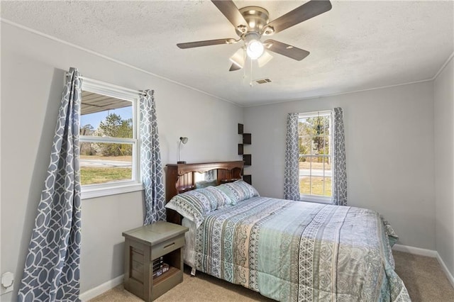 bedroom featuring light carpet, ceiling fan, a textured ceiling, and baseboards