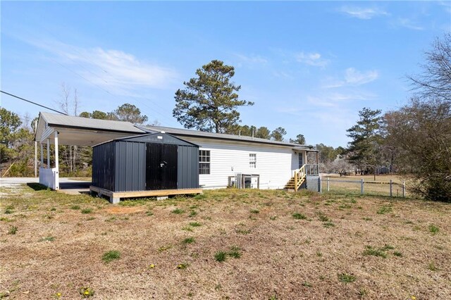 rear view of property with a carport and fence