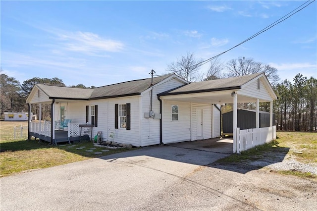 view of front of property with a shed, an attached carport, driveway, and an outdoor structure